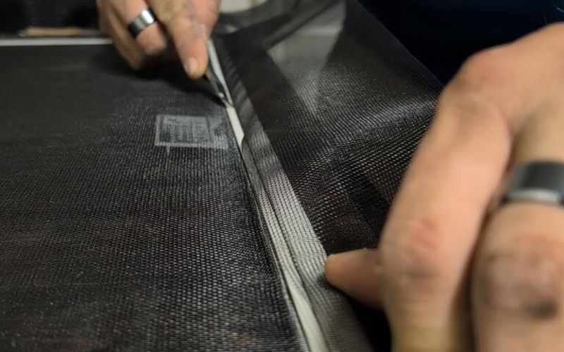 Rescreening a damaged window screen with fresh mesh and new spline.